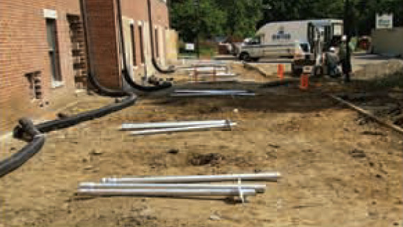 A picture of piles of metal pipes on the ground outside of Montgomery Hall