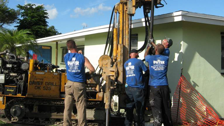 Four workers working on a drill outside of a residential Home