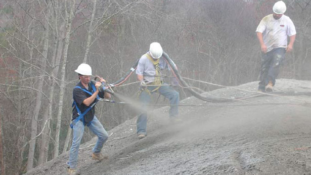 Image of three workers spraying cement on a curve