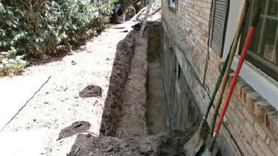 an image of a trench around a residential home foundation
