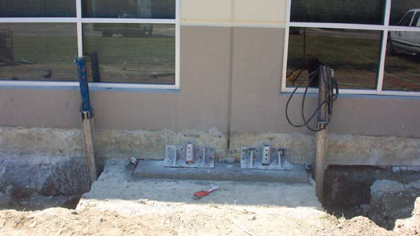 a photo of the side of a commercial building with ground supports