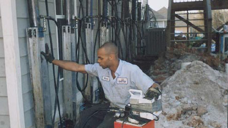 an image of a man pacing his hand on a ground support on a residential building