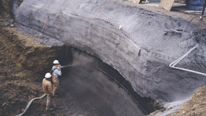 an image of two workers spraying cement on to a wall