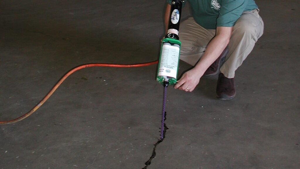 an image of a worker using epoxy injection to fix a crack in a cement floor