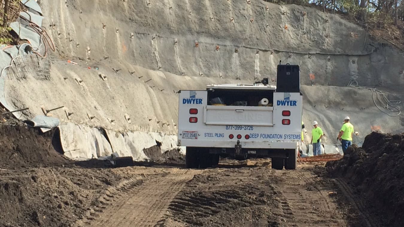 A picture of the back of a truck next to a sloping hill with earth retaining services