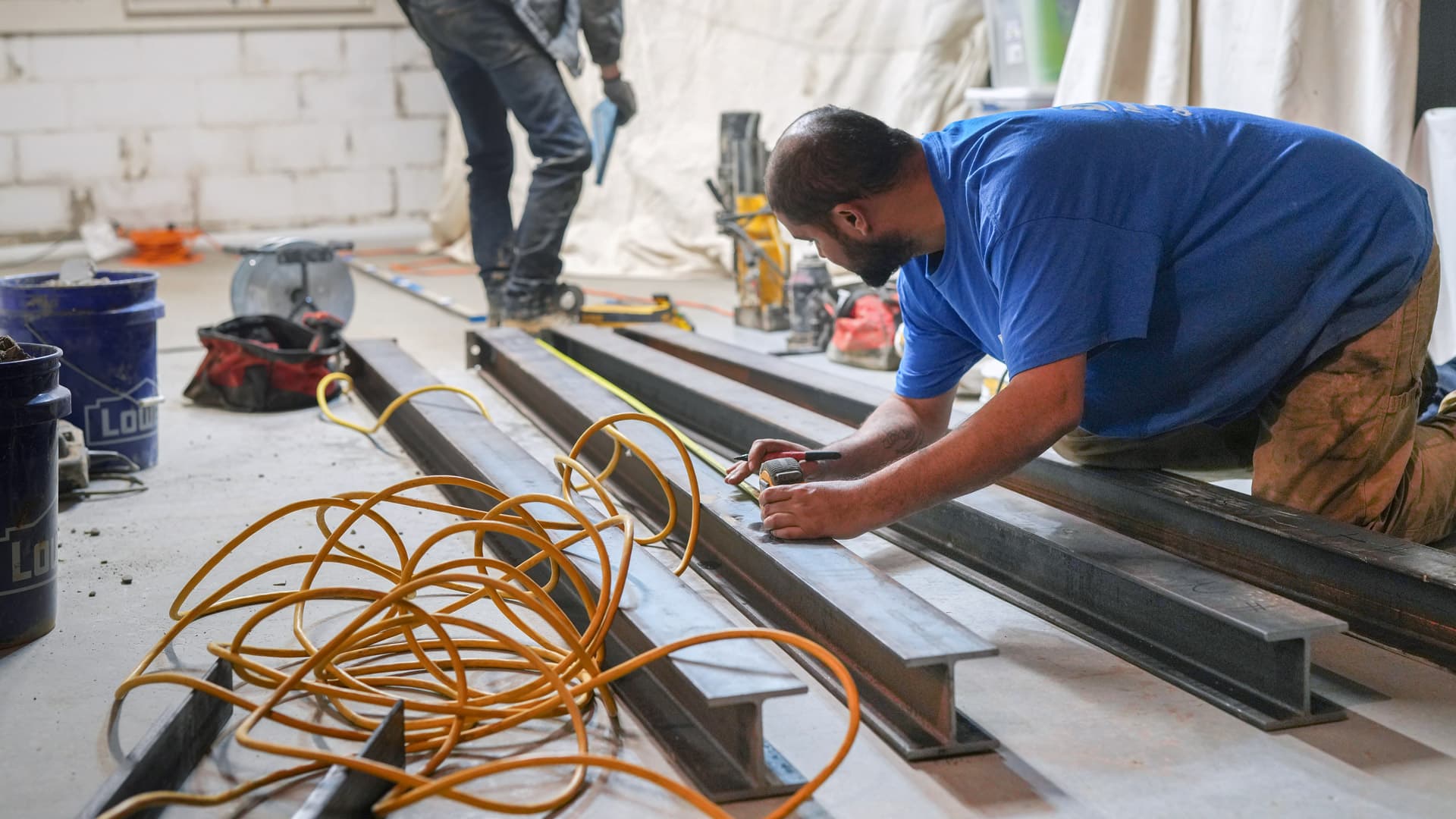 an image of a worker measuring a steel pilaster system